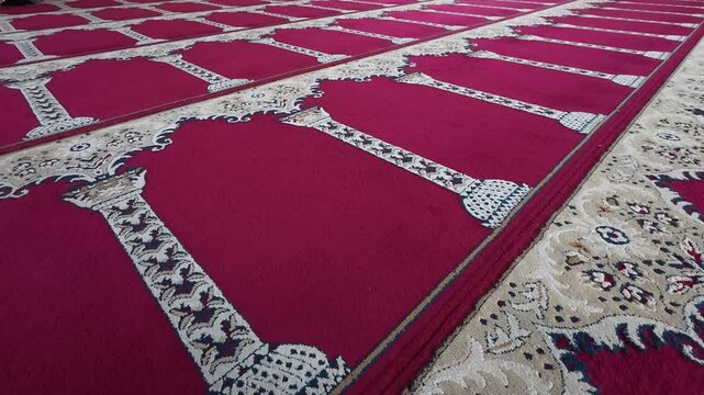 Red patterned mosque prayer carpet viewed from low perspective