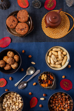 Food themed still life with crockery, various nuts and tea. Flat lay. Top view.