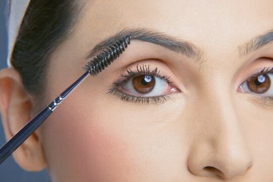 Close-up shot of young woman with an eyebrow tinting applicator 