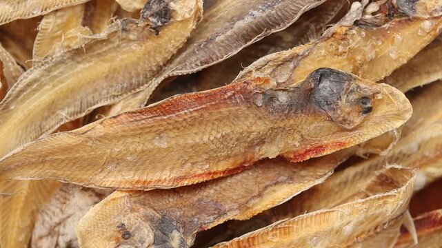 A pile of dried sole fish slowly rotating, Top view shot