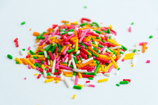 Pile of bright rainbow colorful sprinkles vermicelli isolated on a white background