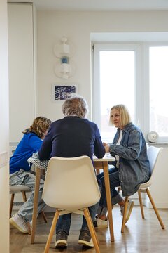 Three family members sitting together in a bright and comfortable home interior