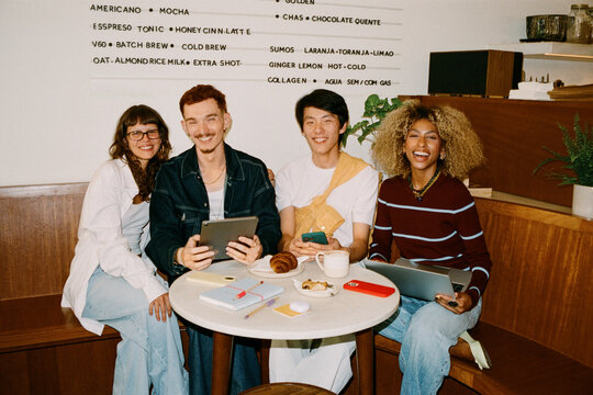 Gen Z business team collaborating at cafe table