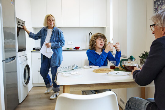 Three family members eating breakfast in a bright and comfortable home interior