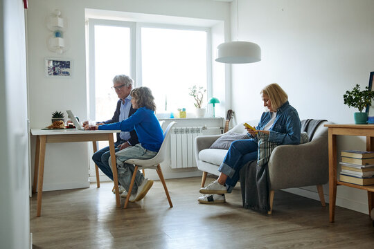 Three family members using devices during an everyday family activity at home