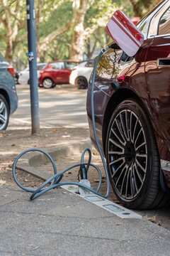 Ein E-Auto wird an einem Ladebordstein auf der K&Ouml; mit einem Kabel aufgeladen, D&uuml;sseldorf, Deutschland