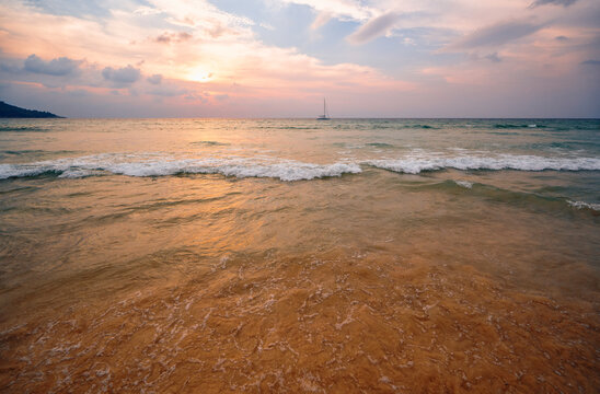 Sunset Over a Serene Beach with Gentle Waves and Calm Waters