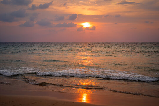 Serene Sunset Over Gentle Waves at a Tranquil Beach