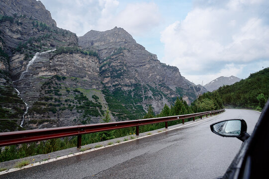 Scenic Mountain Road View with Cliff Waterfalls Amidst Lush Greenery and Forest