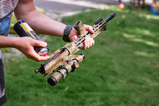 Person cleaning Into Camouflaged AR Rifle  Upper During Outdoor Maintenance
