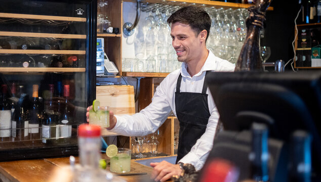 Smiling Bartender Working Behind the Bar in a Restaurant