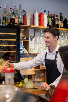 Smiling Bartender Working Behind the Bar in a Restaurant