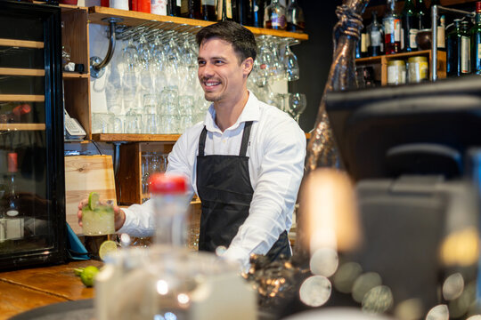 Smiling Bartender Working Behind the Bar in a Restaurant