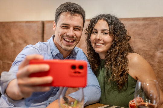 Happy Couple Taking a Selfie While Dining at a Restaurant