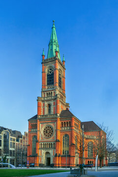 St John Church in Dusseldorf, Germany, front view. Historic gothic revival architecture under clear blue sky without snow