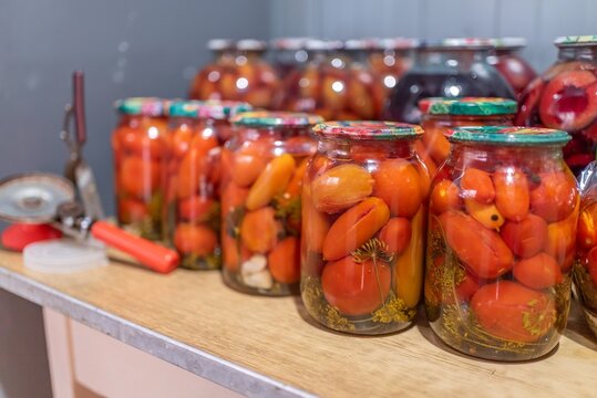 Glass jars filled with pickled tomatoes and dill close up