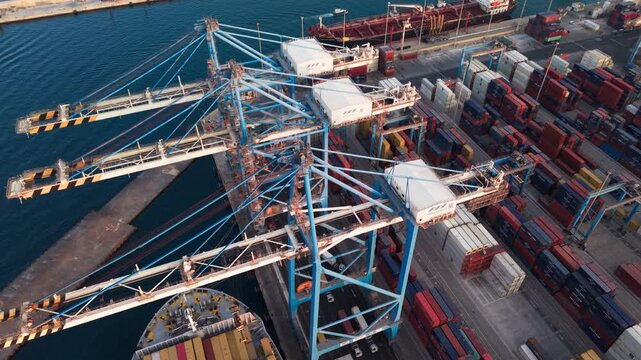 MFT Birzebbugia, Malta - August 10, 2026:  Malta Freeport Terminal - Aerial drone push in shot - With gantry cranes and trucks during golden hour sunset