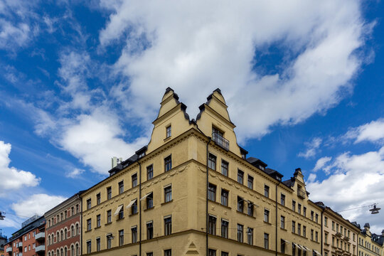 Yellow residential building architecture under blue sky in Vasastan
