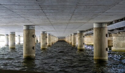 Fototapeta premium Concrete bridge pillars creating leading lines under structure