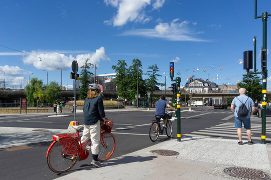 People cycling and waiting at Stockholm city street crossing