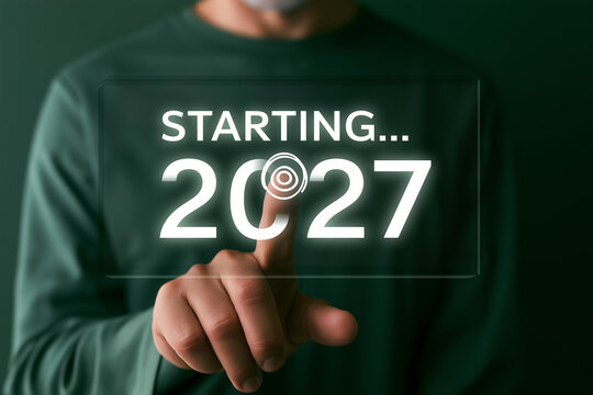 Hand pressing digital start button for new year 2027 business launch and fresh beginnings