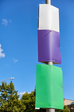 Drei leere Wahlplakate in Wei&szlig;, Violett und Gr&uuml;n als Mockup Template an Laternenmast in Berlin