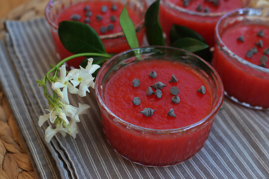 Close-up of traditional Sicilian Watermelon Puddings called Gelo di Mellone with chcolate chips  in glass bowls on woodne table with jasmin flowers