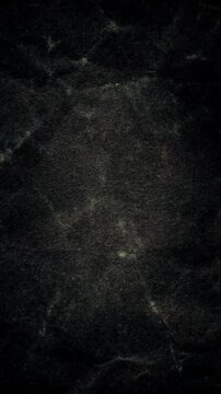 Dark Vintage Grunge Background. Flickering grain, cloudy stains and worn marks drift across a distressed black texture.