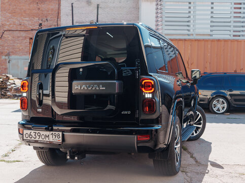 Black modern Haval H9 SUV car with protective polyurethane paint protection film PPF wrapped on body bodywork parked on an urban street near building facade, exterior view of premium chinese SUV car. 