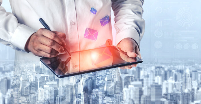 A professional man engages with a tablet to send an email, showcasing modern communication methods against a city skyline, symbolizing innovation and connectivity. Gantry