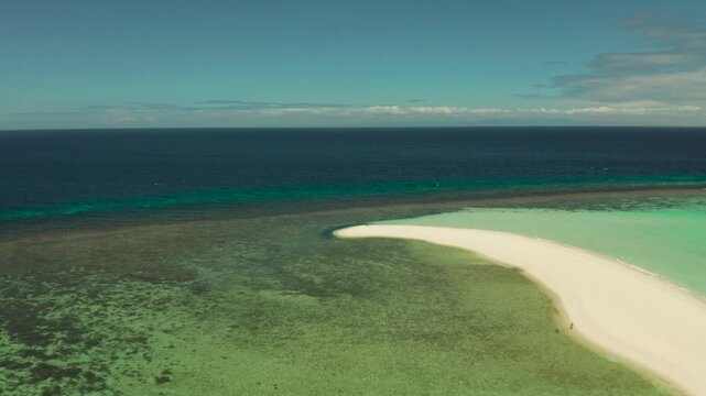 Beautiful beach on tropical island surrounded by coral reef, sandy bar with tourists, top view. Sandbar Atoll. Summer and travel vacation concept, Camiguin, Philippines.