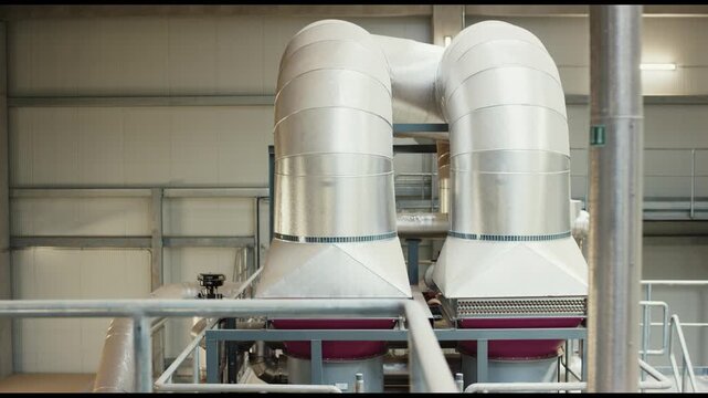 Two cyclone separators above red machine on plant walkway