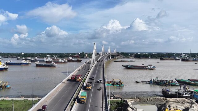 Aerial view of Karnaphuli 3rd Bridge over the river with cargo ships and traffic in Chittagong, Chittagong Division, Bangladesh.