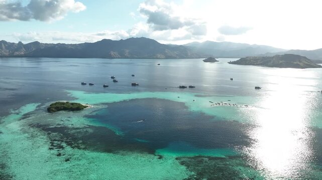 Aerial view of Taka Makasar sandbar surrounded by turquoise waters and coral reefs in Komodo, East Nusa Tenggara, Indonesia.