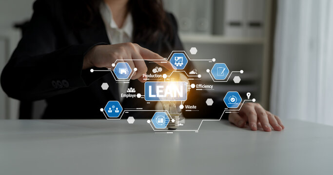 A business professional highlights lean management concepts in a modern workspace, focusing on efficiency and waste reduction with innovative strategies. Tessel