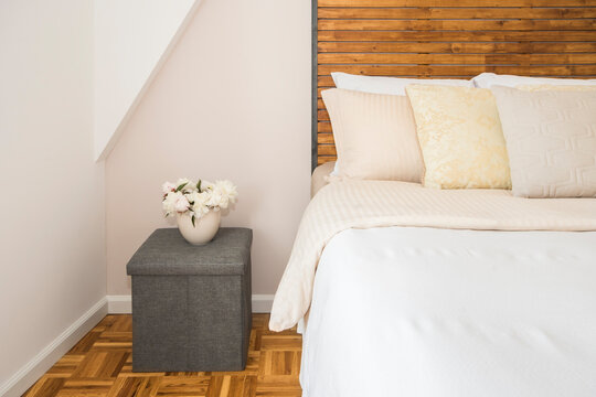 Bedroom with flowers, a nicely made bed and pillows