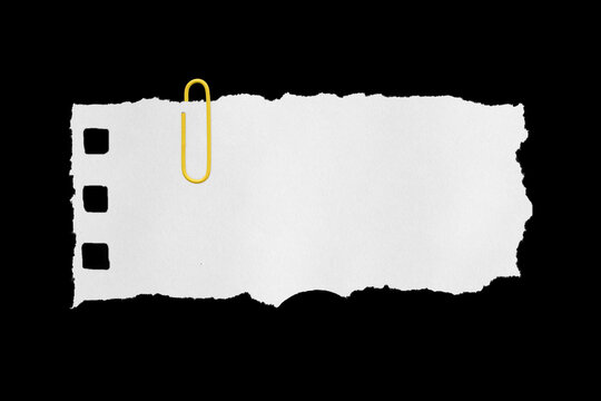 white sheet torn from a notebook on a black background with a colored paper clip
