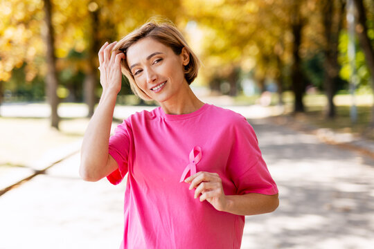 Woman supporting breast cancer awareness holding pink ribbon