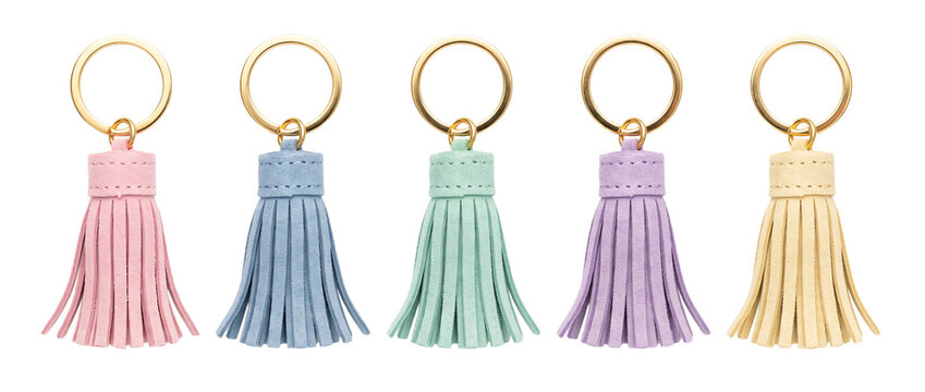 Leather tassel keychain set colorful pastel bag charms on black background isolated row of gold ring keyring accessories for handbag decoration stylish craft fringe embellishments product mockups.