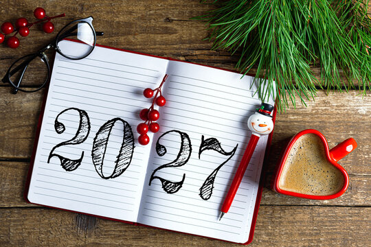 New year resolutions 2027 on desk. 2027 resolutions list with notebook, coffee cup on wooden table. Goals, resolutions, plan, action, checklist concept. New Year 2027 template, copy space