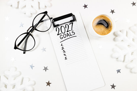New year resolutions 2027 on desk. 2027 resolutions list with notebook, coffee cup on table. Goals, resolutions, plan, action, checklist concept. New Year 2027 template, copy space
