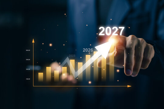 Business growth chart rises toward 2027 as professional points at increasing financial graph, representing revenue forecast, investment success, economic growth, and future strategy.
