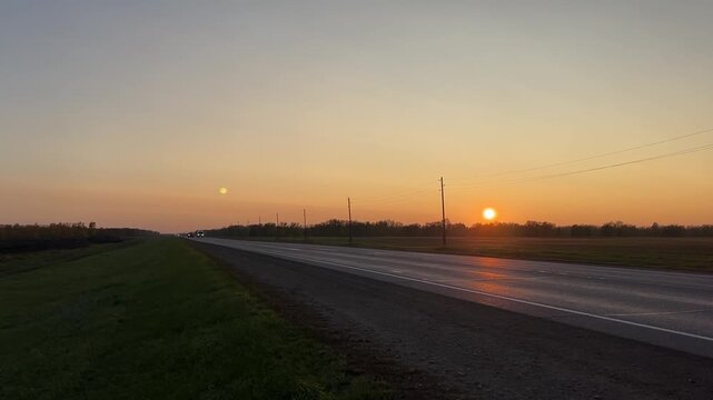 Truck and car driving on highway in Altai Krai at sunset