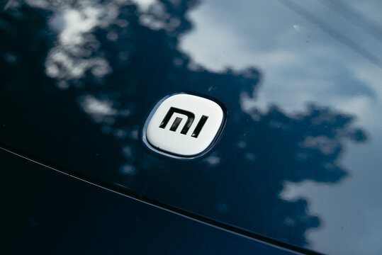 Smolensk, Russia 08.08.2026 Xiaomi SU7 A logo is displayed on a surface reflecting natural surroundings