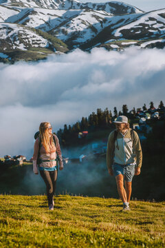 Couple friends man and woman hiking in Georgia family travel vacations explore Caucasus mountains together, romantic tour summer adventure healthy lifestyle outdoors - people enjoying Gomis Mta view