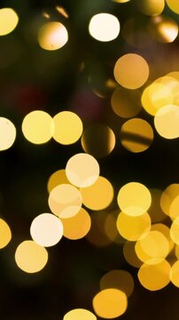 Beautiful warm yellow and golden holiday fairy lights shimmering in out of focus background creating a soft abstract bokeh effect.