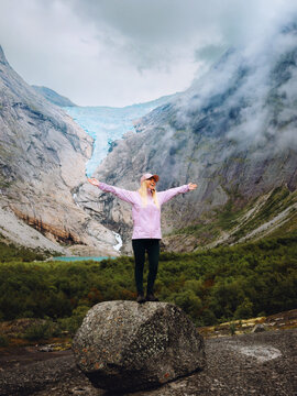 Woman enjoying Briksdalsbreen glacier view travel solo in Norway tourist hiking in mountains active summer vacations healthy lifestyle tour explore Stryn, freedom harmony with nature candid emotions