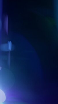 Real Anamorphic Lens Flares. Camera-captured blue optical flares and light leaks fast drift across a dark background with soft cinematic glow.