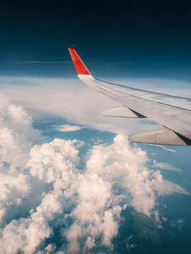 Air travel - Jet flying high above clouds view passenger window aerial view scenic flight airplane wing and sky, public transportation overseas vacation