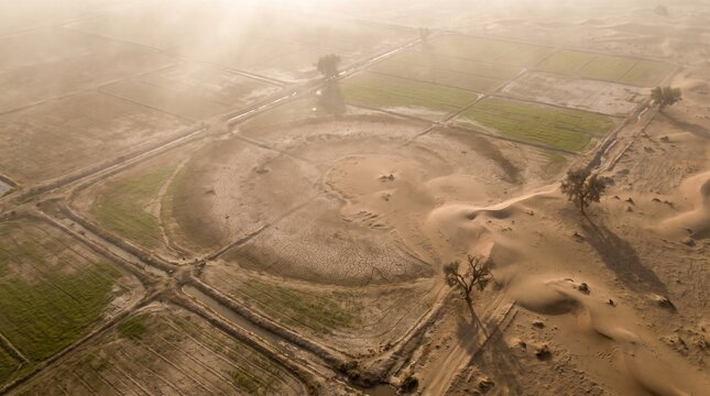 Aerial View of Desertification Encroaching on Agricultural Farmland at Sunset